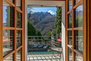 an open door to a balcony with a view of the mountains at Mille Colline la Casa 1 with Shared Pool - Happy Rentals in Pianezzo