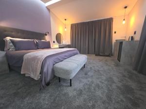 a large bedroom with a large bed and a chair at Terra Nova Suites and Spa in Gqeberha