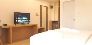 ein Zimmer mit Fernseher und Bett in einem Zimmer in der Unterkunft Ceniq Hotel in Sathani Nakhon Lampang + 24 Fotos