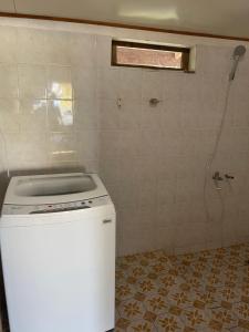 a washing machine in a bathroom with a shower at NAEHU TEMAUI A MATUANUI Lodge in Tiputa
