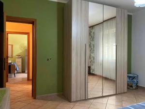 a room with green walls and a sliding glass door at Le case di Helga in Budoni