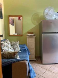 a room with a refrigerator and a dresser with a mirror at Le case di Helga in Budoni