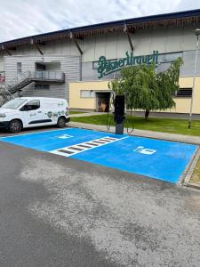 a car parked in front of a building with a blue driveway at Buly Aréna in Kravaře