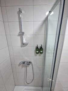 a bathroom with a shower with two bottles on the wall at Stan na dan Alisa Cazin in Cazin +17 photos