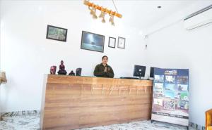 a woman sitting at a counter in a room at Blue River Resort in Rāmnagar +14 photos