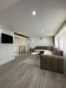 a living room with a couch and a flat screen tv at Čaršija Light Visoko in Visoko