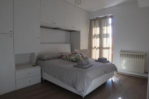 a white bedroom with a bed and a window at Murazzanino in Murazzano