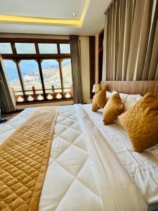 a large bed in a room with a large window at Dema Rresort in Paro