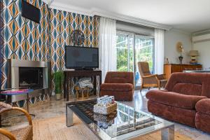 a living room with a couch and a tv at Villa Montplaisir 180m² - Jacuzzi in Charmes-sur-Rhône