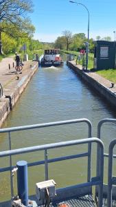 a boat in a canal with a barge in it at Logis Hôtel Relais de Vincey in Vincey