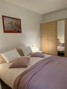 a bedroom with a large bed with two pillows at Apartments Mareblu in Rabac