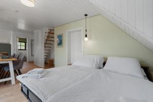 a white bed in a room with a staircase at Das BRIX I Apartments zwischen See & Wald in Immenstaad in Immenstaad am Bodensee
