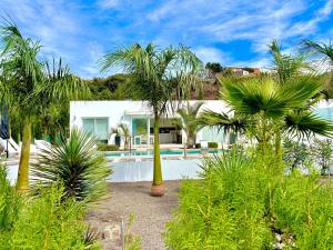 a white house with palm trees in front of it at Casa Tajuya in Los Llanos de Aridane