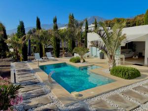 a swimming pool in a yard with palm trees at Casa Tajuya in Los Llanos de Aridane +26 photos