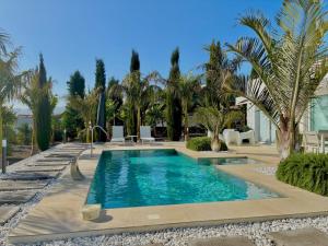a swimming pool in a resort with palm trees at Casa Tajuya in Los Llanos de Aridane