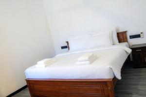 a bedroom with a large bed with white sheets at Diana Residence in Matara