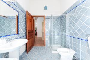 a blue tiled bathroom with a sink and a toilet at Luna in Onifai +31 photos