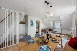 a dining room and living room with a table and chairs at Das BRIX I Apartments zwischen See & Wald in Immenstaad in Immenstaad am Bodensee
