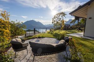 two chairs and a couch on a patio with a view at Retrait Lake Como Private Design Retreat with Lake View in Perledo