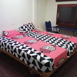 a bed with a black and white comforter on it at Ezhimala cruise in Nīleshwar +3 photos