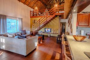 a living room with a couch and a staircase at Spacious Family Villa, close to Krugerpark entrance in Phalaborwa