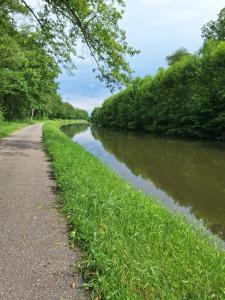 a river with a path next to a road at Logis Hôtel Relais de Vincey in Vincey