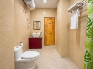 a bathroom with a toilet and a sink and a door at hotel pema kara in Paro