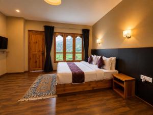a bedroom with a large bed and a window at hotel pema kara in Paro