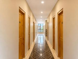 a hallway with wooden doors and a tile floor at hotel pema kara in Paro