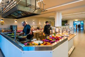 two men standing in a kitchen preparing food at Lagomandra Hotel and Spa in Lagomandra