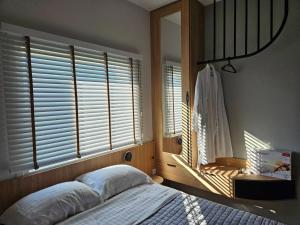 a bedroom with a bed and a window with blinds at Like home in Samothraki 2 in Kamariotissa