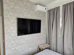 a bedroom with a wall with a tv on a wall at Like home in Samothraki 2 in Kamariotissa