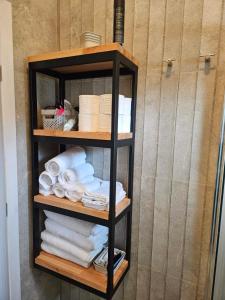 a shelf filled with towels in a bathroom at Like home in Samothraki 2 in Kamariotissa +19 photos