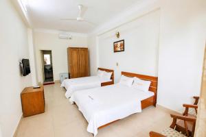 a room with two beds and a television in it at King Hotel Sầm Sơn in Sầm Sơn
