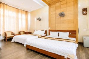 a bedroom with two beds and a window at King Hotel Sầm Sơn in Sầm Sơn