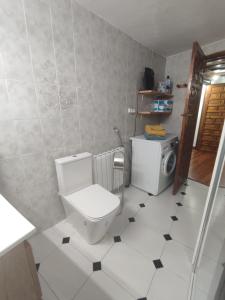 a bathroom with a toilet and a washing machine at Casona de Barrabás in San Vicente de la Sonsierra +16 photos