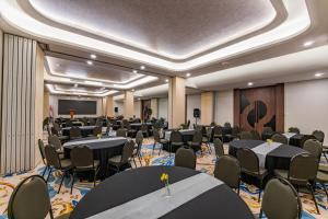 a conference room with tables and chairs and a podium at Azana Boutique Hotel Solo in Purwosari +18 photos