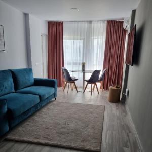 a living room with a blue couch and a table at Olimp Panoramic Sea View in Olimp