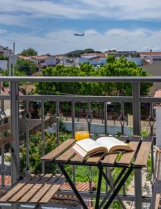 a wooden table with a book and a glass of orange juice at Central Guest House Skiathos in Skiathos