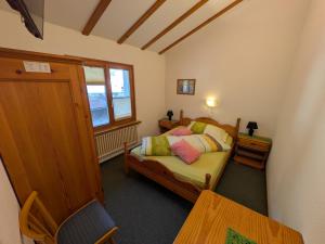 a small bedroom with a bed and a window at Hotel Foppoli in Poschiavo
