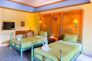 a room with two beds with swans on them at Pung-Waan Resort & Spa in Kanchanaburi City
