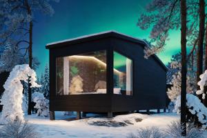 a black cabin with a window in the snow at ALVA Resort in Rovaniemi