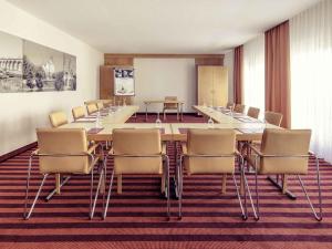 a conference room with a long table and chairs at Mercure Hotel Ingolstadt in Ingolstadt