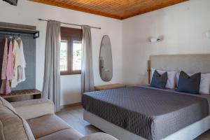 a bedroom with a bed and a couch and a window at Central Guest House Skiathos in Skiathos