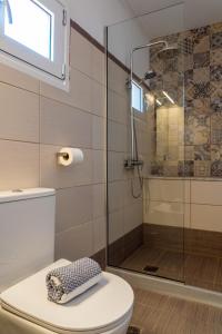 a bathroom with a toilet and a glass shower at Central Guest House Skiathos in Skiathos +44 photos