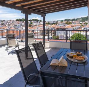 a table with books and a plate of food on a balcony at Central Guest House Skiathos in Skiathos