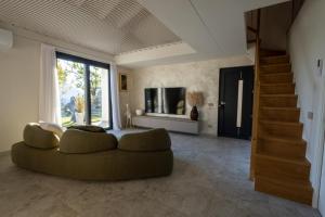 a living room with a couch and a television at Retrait Lake Como Private Design Retreat with Lake View in Perledo