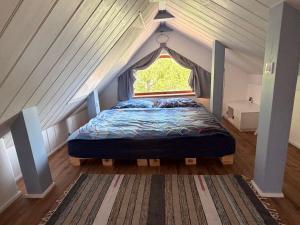 a bed in a room with a window in a attic at Sunrise Tiny House Malešov in Malešov