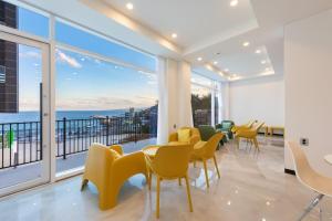 a room with chairs and tables and a large window at Donghae 828 Spa Pension A in Donghae
