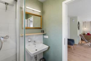 a bathroom with a sink and a mirror at Das BRIX I Apartments zwischen See & Wald in Immenstaad in Immenstaad am Bodensee +74 photos